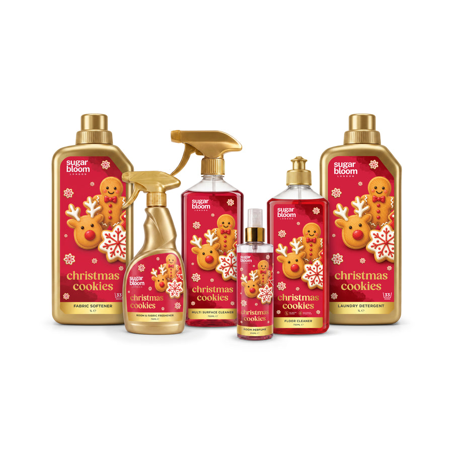 A collection of Puder Bloom 'Christmas Cookies' fragrance products, including a large softener bottle, a spray bottle, a room spray bottle, and two body mists, all featuring festive red and gold holiday illustrations of gingerbread men and snowflakes.